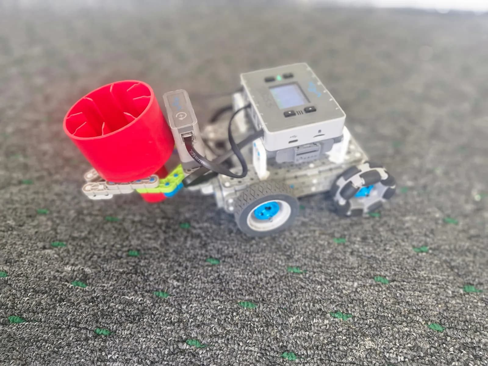 A VEX robot with a red carrying basket built during robotics class