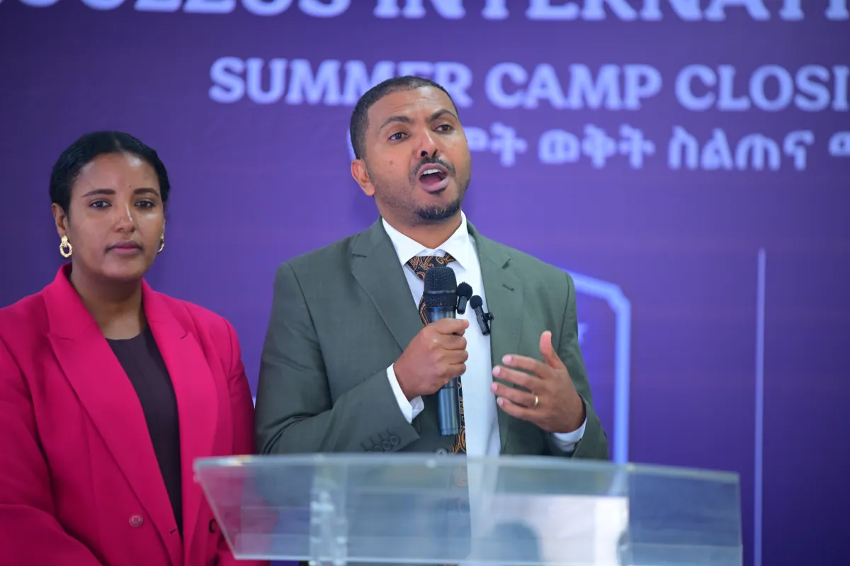 A member of the Nucleus leadership team addressing parents at the summer camp closing ceremony