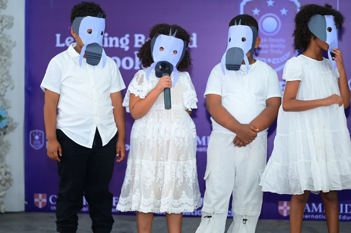 Four campers dressed in white wearing hand-made bird masks performing a drama piece on stage