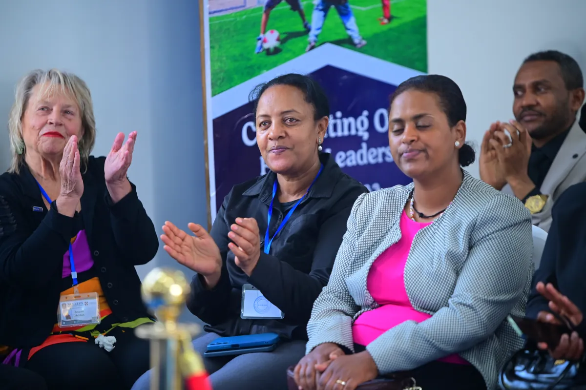Parents seated in the audience applauding during the Nucleus summer camp closing ceremony in Addis Ababa