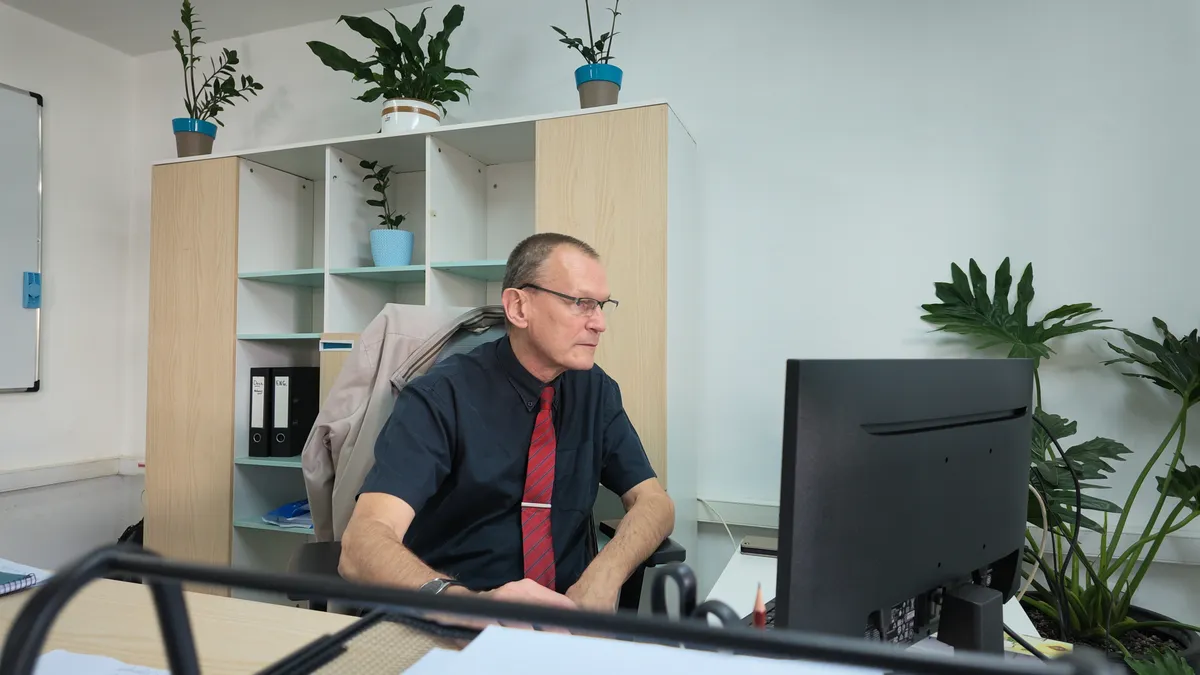 Daniel Hiest working at his computer in the School Director’s office at Nucleus International Schools
