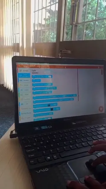 A laptop screen showing a block-based coding program at Nucleus